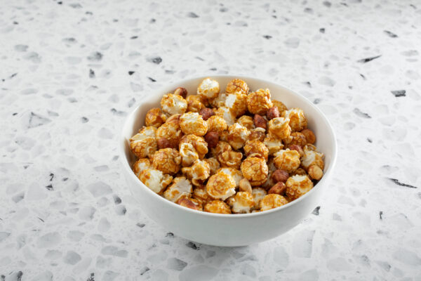 A view of a bowl of caramel coated popcorn snack.