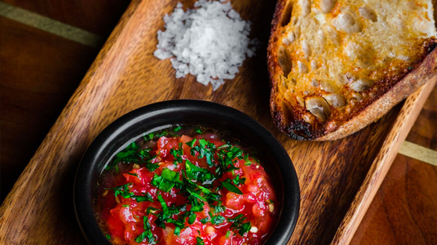 Pan con tomate y boquerones with marinated and salt-cured anchovies, tomato chutney and fried shallot salsa verde at The Pawn Shop in San Francisco.