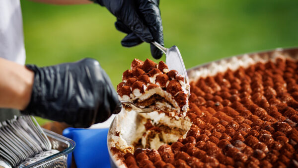 Tiramisu being served by a gloved chef outside