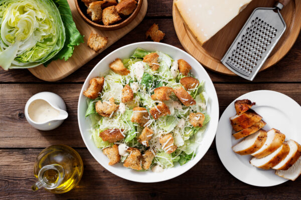 Classic caesar salad with grilled chicken fillet and parmesan cheese. top view