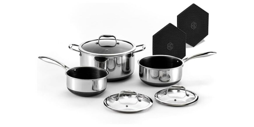 set of three stainless steel pots with lids and two black trivets on a white background