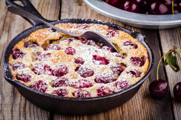 Clafoutis cherry pie on rustic wooden background