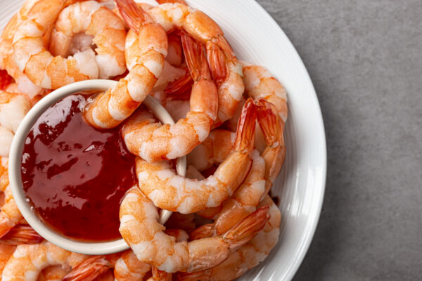 Food cocktail shrimp dipping shrimp in cocktail sauce