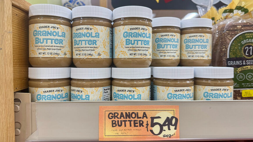 Shelves stocked with Trader Joe's Granola Butter in 12-ounce jars, with a store price tag showing $5.49.