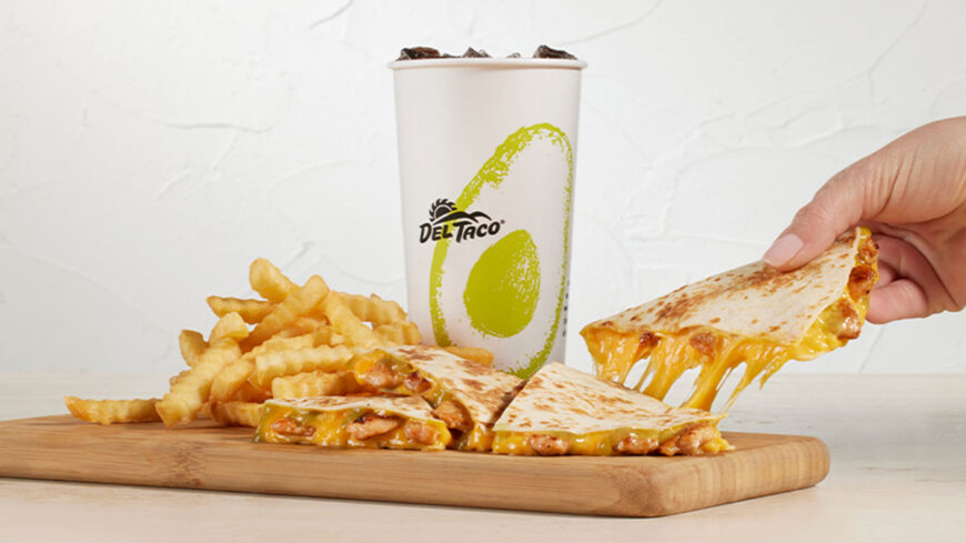 Del Taco meal featuring cheesy quesadilla wedges, crinkle-cut fries, and a branded drink cup, with a hand holding a cheesy quesadilla in the background.