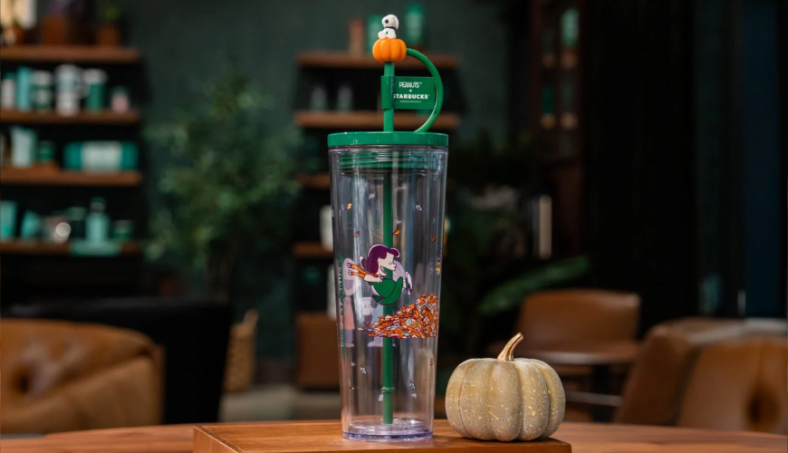 Clear plastic cup with Peanuts characters on it and Snoopy straw topper