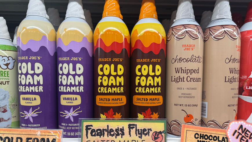 Trader Joe’s cold foam creamers in vanilla and salted maple flavors displayed alongside chocolate whipped light cream.