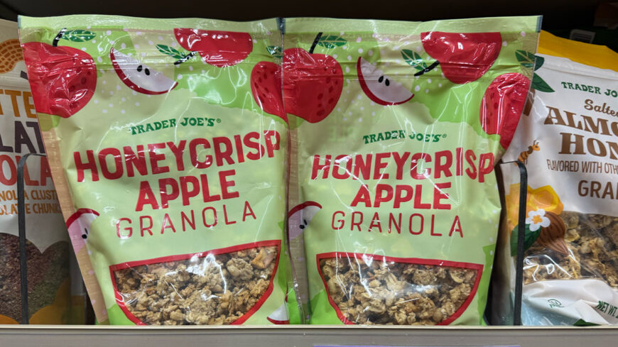 Two bags of Trader Joe’s Honeycrisp Apple Granola with green packaging decorated with red apples and apple slices.