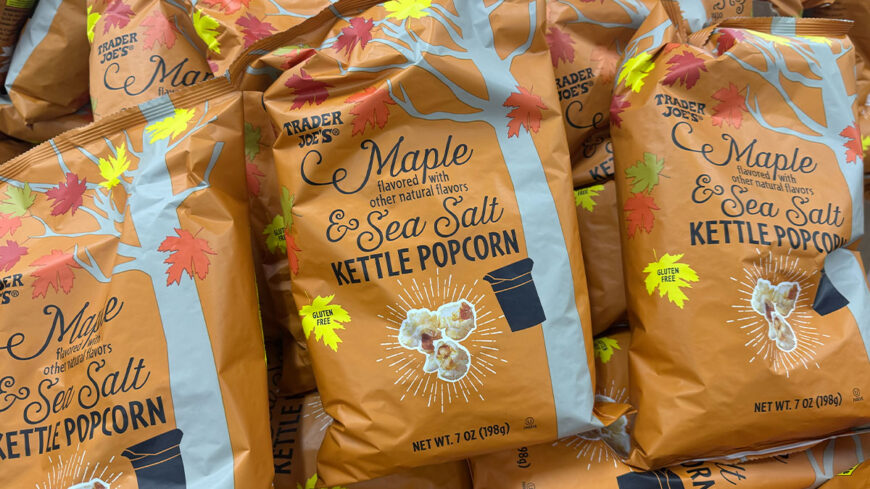 Several bags of Trader Joe’s Maple Sea Salt Kettle Popcorn stacked on a shelf.