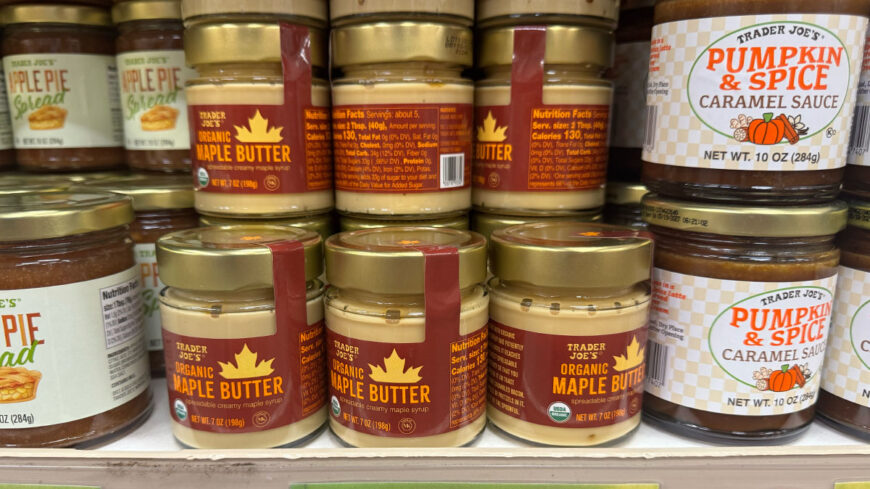 Jars of Trader Joe’s Organic Maple Butter displayed on a grocery store shelf alongside Pumpkin & Spice Caramel Sauce and Apple Pie Spread.