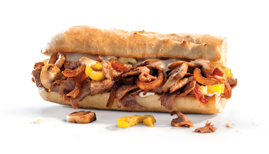 Philly cheesesteak sandwich on a toasted sub roll, filled with sliced grilled steak, sautéed mushrooms, onions, and melted cheese.