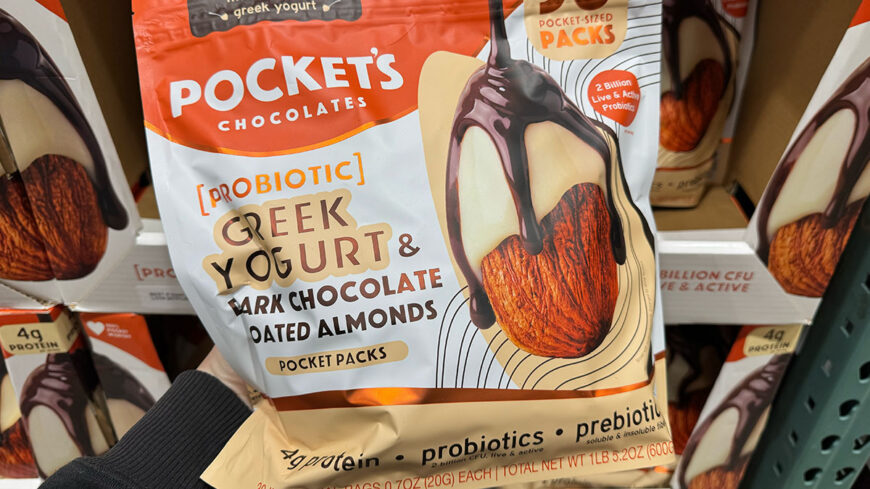 Bag of Greek yogurt and dark chocolate-coated almonds in individual pocket-sized packs, labeled with 4 grams of protein and probiotics.