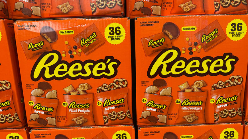 Large orange boxes of Reese’s candy assortment containing dipped animal crackers, filled pretzels, and dipped pretzels.