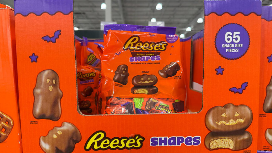 A display of Reese’s Shapes peanut butter and milk chocolate candies in Halloween-themed packaging.